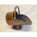 A Victorian copper traditional coal helmet with swing handle on circular base