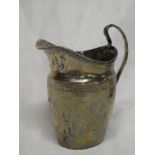 A George III silver classical-shaped cream jug with engraved decoration on loop handle,