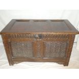 An 18th Century carved oak rectangular coffer with decorated panels, hinged lid on block feet,