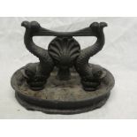 A cast iron foot scraper with dolphin decoration on oval base,