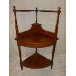 A Victorian walnut two tier corner washstand surmounted by turned supports and towel rails
