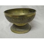 A 19th Century Eastern brass circular pedestal bowl with raised scroll decoration,