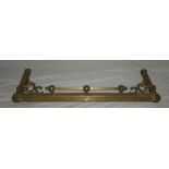 An old brass rectangular fire fender with scroll decoration