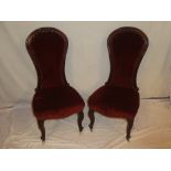 A pair of Victorian carved mahogany occasional chairs upholstered in fabric on scroll-shaped legs
