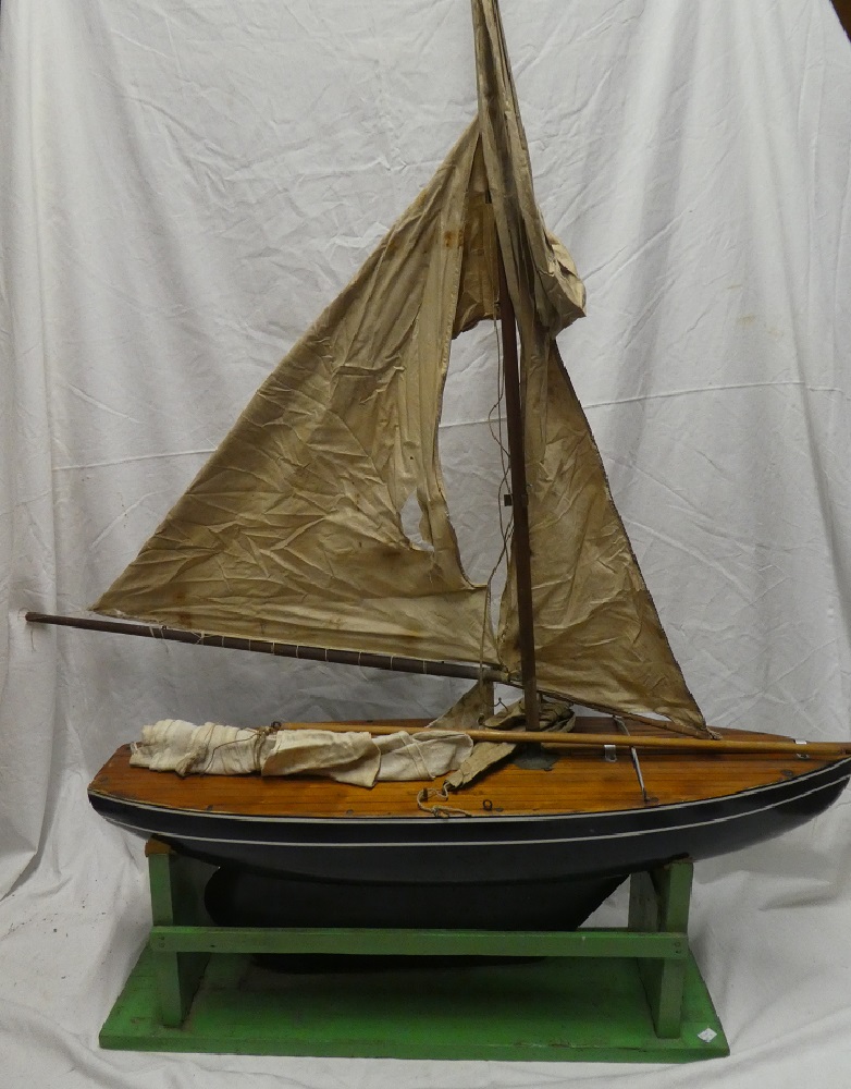 An old wooden model pond yacht with mast, sails and stand,