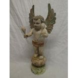 A painted wood figure of a winged cherub on circular base,