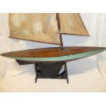 An old wooden model pond yacht with linen sails and stand,