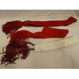 Two military scarlet cloth ceremonial sashes with tassled ends and a similar blanco fabric military