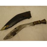 A Gurkha kukri dagger with curved single edged blade in leather scabbard