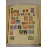 An old folder album containing Commonwealth stamps,