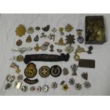 A selection of mixed military badges including Royal Marine helmet plate, Black Watch,