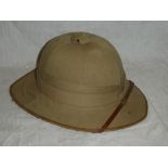 A khaki Foreign Service pith helmet with leather strap