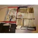 A box containing numerous packets of World stamps together with various album pages and stock cards