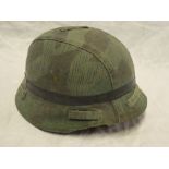 A Second War German steel helmet in relic condition with later camouflage cover