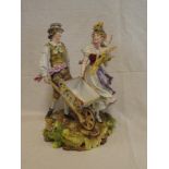 A German porcelain figure of a male with wheelbarrow and female with flowers on rustic circular