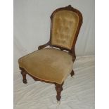 A Victorian carved walnut easy chair with upholstered seat and back on turned tapered legs with