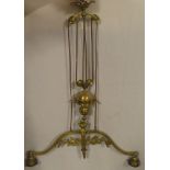 An ornate brass hanging rise-and-fall twin branch light fitting with raised leaf decoration and