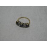 An impressive 18ct gold dress ring set three sapphires and four diamonds