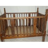 A large Colonial teak child's folding cot/bed with spiral twist supports and cane work base,