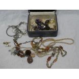 A jewellery box containing a quantity of various costume jewellery including necklaces, brooches,