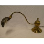 An old brass piano/desk lamp with scallop-shaped cover