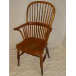 A good quality polished elm and beech Windsor armchair with spindle back and shaped seat on turned