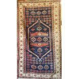 An Eastern rectangular wool rug with geometric decoration on blue, red and cream ground,