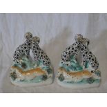 A pair of 19th Century Staffordshire pottery figures of Dalmatian dogs with deer on rustic bases,