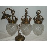 Three matching brass hanging light shades with coronet tops and cut glass shades,