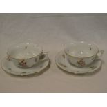 A pair of Hungarian Herend china tea cups and saucers with painted floral decoration