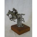 A chromium plated vehicle mascot in the form of a horse and rider jumping a fence,