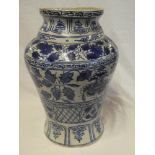 A large Eastern pottery tapered vase with painted blue and white floral and geometric decoration,