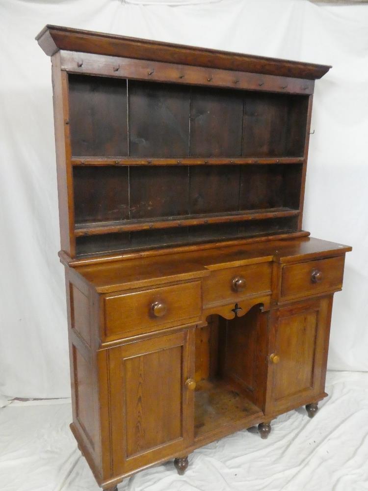 A 19th Century polished pitch pine kitchen dresser with three small drawers in the frieze,