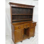 A 19th Century polished pitch pine kitchen dresser with three small drawers in the frieze,