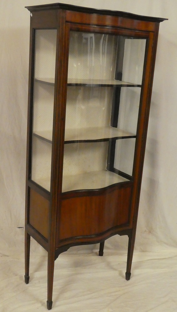 A late Victorian inlaid mahogany bow fronted display cabinet with fabric lined shelves enclosed by