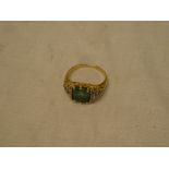 A 19th Century 18ct gold dress ring set a central emerald flanked by diamonds