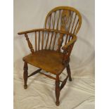 A 19th Century elm and ash Windsor-style armchair with shaped seat on turned tapered legs