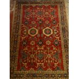 A 19th Century Eastern hand-knotted wool rug with floral and scroll decoration on red and blue