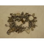 A silver chain bracelet mounted with over 30 silver charms