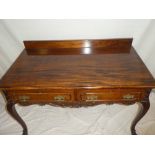 An Edwardian mahogany rectangular side table with two drawers in the frieze on scroll shaped legs