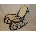 An old bent wood traditional rocking chair with upholstered seat and back