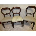 A set of four Victorian mahogany balloon back dining chairs with upholstered seats on turned