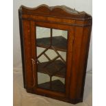 A 19th Century oak hanging corner cupboard with shelves enclosed by a central glazed door