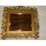 A good quality old bevelled square wall mirror in gilt holly, ivy leaf and berry decorated frame,