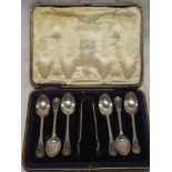 A set of six George V silver teaspoons and matching sugar tongs with pierced scroll handles,