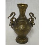 An Indian brass baluster-shaped vase with animal handles and engraved decoration,