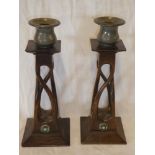 A pair of unusual 1930's carved oak candlesticks with beaten pewter sconces and raised