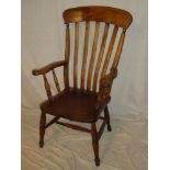An old beech wood kitchen lath-back carver armchair with shaped seat on turned tapered legs