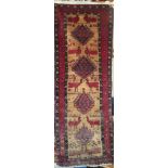 An Eastern hand-knotted wool rug with animal and geometric decoration on red and cream ground,