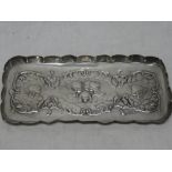 A late Victorian silver rectangular dressing tray decorated in relief with angel's faces and